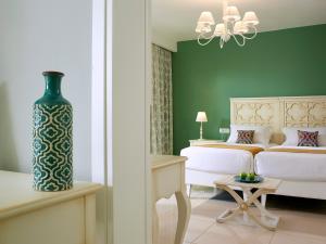 耶奥伊乌波利斯安妮莫斯超豪华度假酒店 的卧室配有白色的床和绿色的墙壁