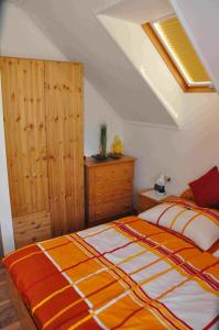 赖兴瑙Familie Stoier的一间卧室配有一张带橙色和白色毯子的床