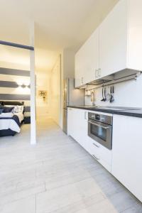 博洛尼亚Dante Suite private parking的厨房配有白色橱柜和一张位于底部的床。