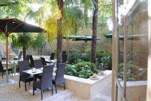 阿尔勒卡隆德尔Spa酒店的一间设有桌椅的餐厅,种植了棕榈树
