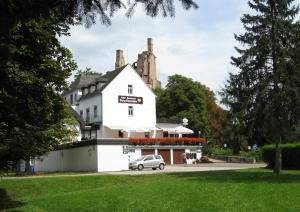 KordelHotel-Restaurant Burg-Ramstein的前面有一辆汽车停放的白色建筑
