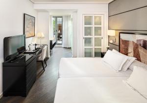 巴塞罗那H10大学酒店的酒店客房设有两张床和一台平面电视。
