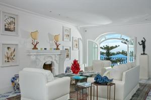 卡普里Hotel La Minerva的客厅配有白色椅子和壁炉
