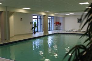 拉姆吉图尔马莱摩尔高尔夫酒店的一座绿色的游泳池,位于一座建筑中