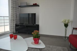 奥斯坦德4B @ Longchamp的客厅配有白色桌子和电视