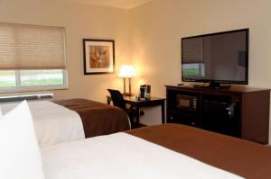 Fort MadisonCobblestone Inn & Suites Fort Madison的酒店客房设有两张床和一台平面电视。