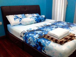 瓜埠斯里特蚌告度假屋的一张带蓝色和白色床单及枕头的床