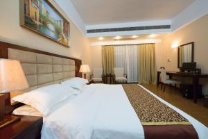 花都悦丰酒店广州银丰国际公寓北站店的卧室配有一张白色大床和一张书桌