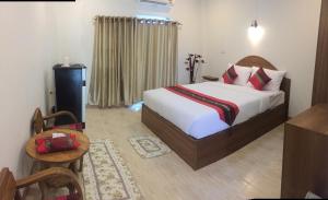 美索梅索特斯里酒店的酒店客房,配有床、桌子和椅子