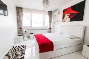 加拉茨Belvedere Danubius的卧室配有一张带红色毯子的白色床