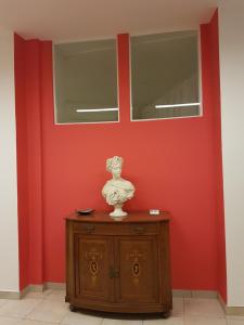 塔兰托Amanda's的橱柜顶部有花瓶的红色墙