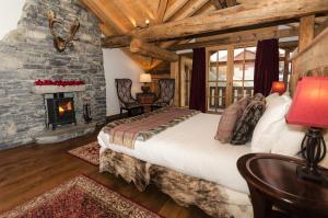 圣福瓦-塔朗泰斯黑钻石度假酒店的一间卧室配有一张床和一个壁炉