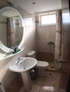 瓦尔索洛米翁Glyfa Beach Hotel的一间带水槽、卫生间和镜子的浴室