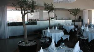 奥利韦拉迪阿泽梅什德通酒店的一间用餐室,配有白色的桌椅和树木