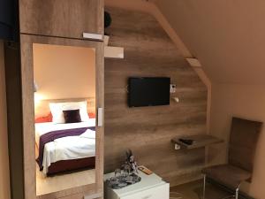尼尔巴托尔绝对酒店及旅馆的一间卧室配有一张床,墙上配有电视