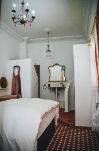 得土安Riad Tetuanía的一间卧室配有一张床、一张桌子和一个吊灯。