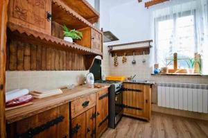 什恰夫尼察Stary Dwór的厨房配有木制橱柜和炉灶烤箱。