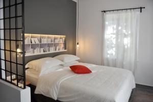 伊兹拉Piteoussa的卧室配有白色的床和红色枕头