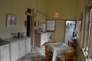 帕克斯Old Parkes Convent的厨房配有桌椅和冰箱。