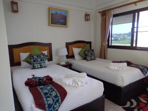 清孔湄公河滨酒店的带窗户的客房内的两张床