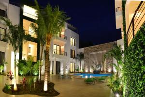 图卢姆图伦艾利曼斯精品酒店的一座带游泳池和棕榈树的建筑的庭院