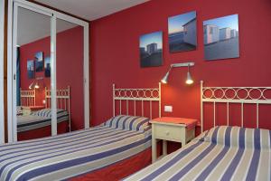 波多黎各米丽亚公寓酒店的一间卧室设有两张床和红色的墙壁
