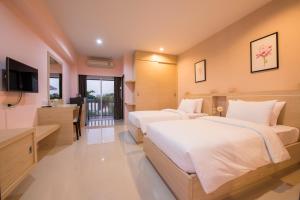 乌汶优杜艾甘花园之家酒店的酒店客房设有两张床和电视。