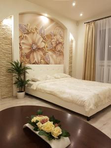 RūjienaLauvas Līcis的一间卧室配有一张床和一张鲜花桌子