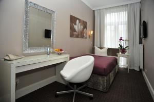 汉堡康莫德瑞酒店的酒店客房,配有床和白色椅子