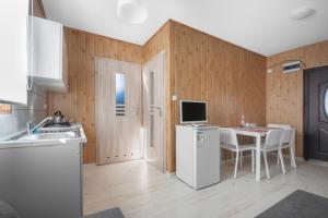 萨比诺瓦Cuma Camp的厨房配有白色冰箱和桌椅