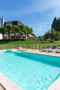 吕克瑟伊莱班Logis Hotel Restaurant Spa Beau Site的一个带椅子的大型蓝色游泳池