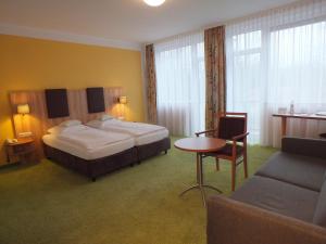 慕尼黑斯塔德特特帕星酒店的酒店客房配有床、桌子和沙发。