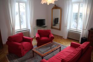 沃尔特湖畔韦尔登Villa Adrienne的客厅配有2把红色椅子和镜子