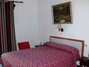 阿尔姆尼卡Casa Mariana的一间卧室配有红色的床和红色椅子