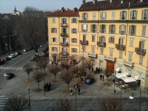 都灵La Terrazza Di Arturo Guest House的一条有汽车的街道旁的黄色大建筑