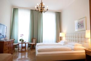 维也纳施瓦尔贝酒店的一间设有两张床和吊灯的大卧室