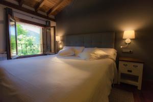奥尼亚特艾瑞吉乡村民宿的卧室配有一张大白色床和窗户