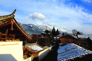 丽江丽江白沙自由岁月设计旅店的享有建筑和山脉雪盖屋顶的景色