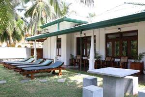卡卢特勒Lohas Beach Resort Villa的一排躺椅在房子前面