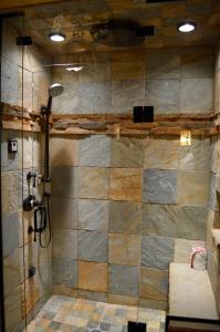 NiwotNiwot Inn & Spa的带淋浴的浴室(带石墙)