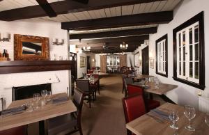 哈里伯顿山姆爵士Spa度假村的餐厅设有木桌、椅子和壁炉