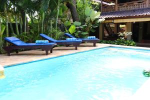 罗威那罗维纳海滩别墅的一座房子旁的游泳池,配有蓝色躺椅