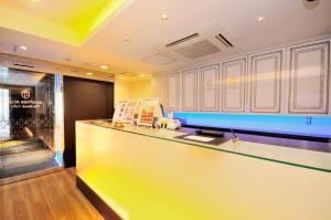 东京北千住格兰帕克Spa胶囊旅馆的厨房设有黄色的柜台和窗户。