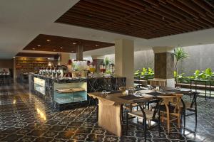 库塔巴厘库塔格兰德祖丽酒店的一间带桌椅的餐厅和一间酒吧