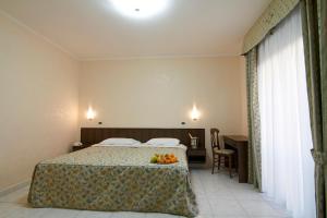 圣乔瓦尼·罗通多Hotel Primula的酒店客房,配有一张带水果的床