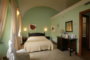 奥里斯塔诺Il大教堂酒店的一间卧室配有一张床、一张桌子和一面镜子