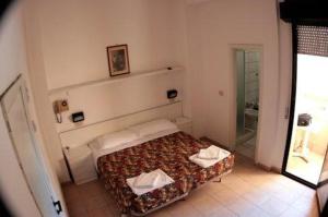 里米尼莎古拉莫拉酒店的一间小卧室,配有一张床和镜子