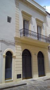 加拉蒂纳Kaleidos Guest House的一座带三扇门和阳台的大型建筑