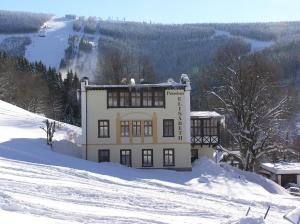什平德莱鲁夫姆林伊丽莎白旅馆的雪中一座被雪覆盖的山丘上的建筑