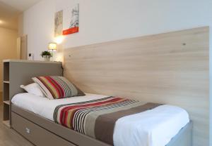 南希南锡公寓式酒店的一间卧室配有一张带大型木制床头板的床